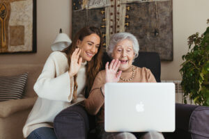 abuela y cuidadora hablando por videollamada