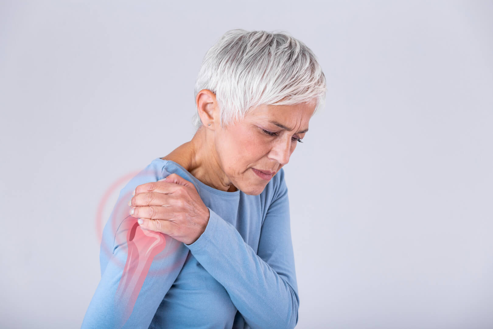 Una mujer mayor se queja de un calambre muscular en el hombro a causa de la hipopotasemia que padece. 