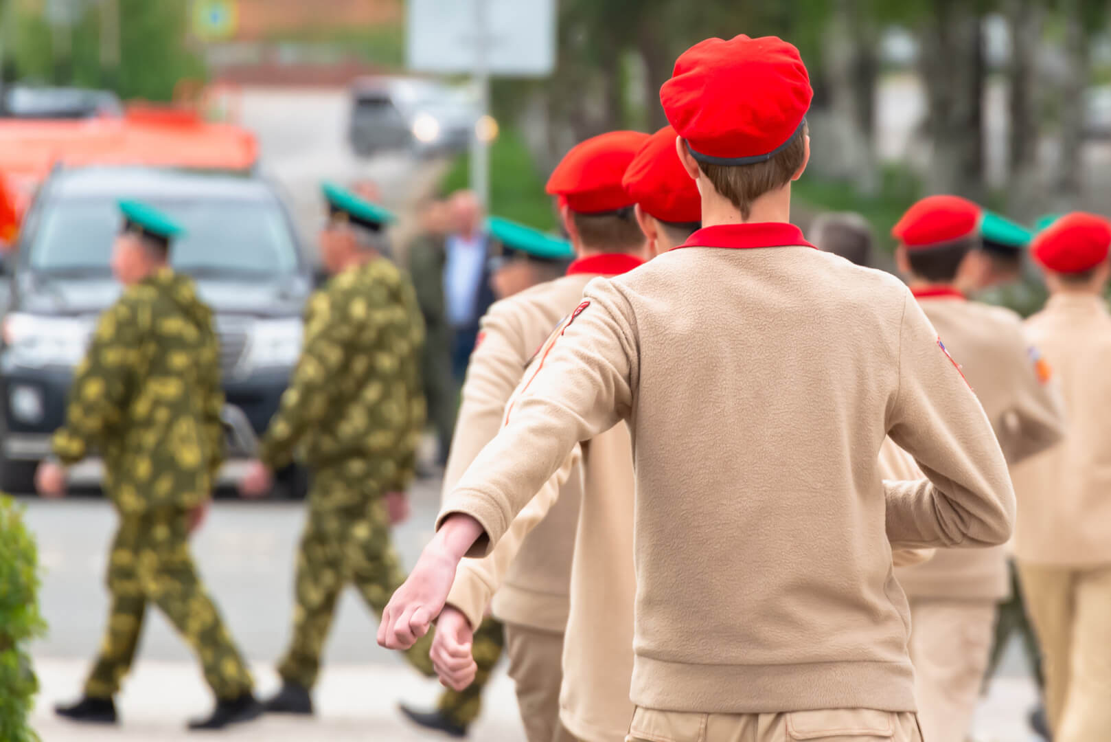 Un grupo de soldados rusos con una boina de color rojo desfilan por la calle. 