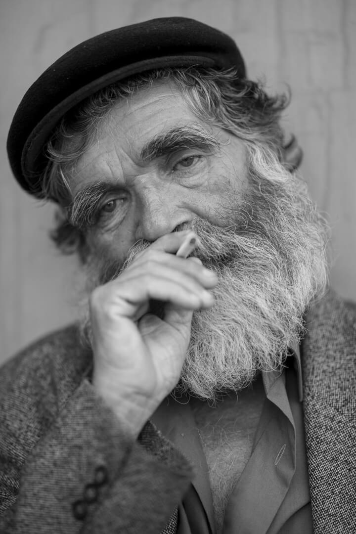 Un hombre mayor francés posa en una fotografía en blanco y negro con una boina.