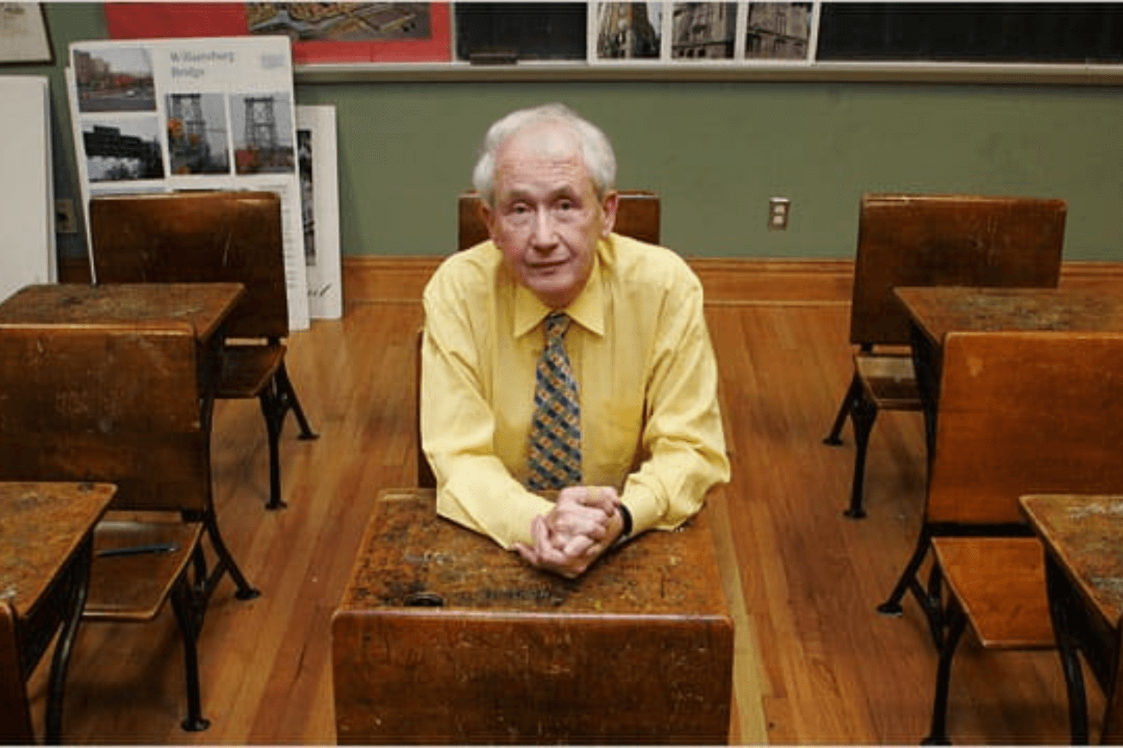Una imagen de Frank McCourt sentado en la silla de un aula de un colegio antiguo. 