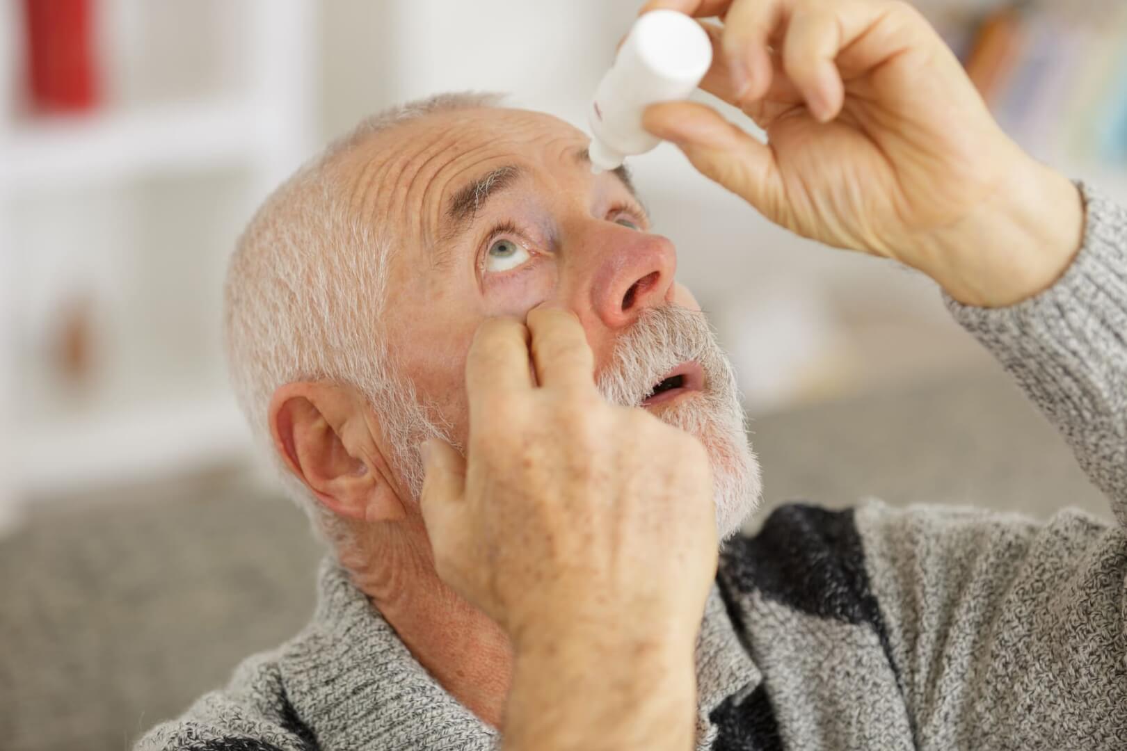 Un señor mayor se introduce unas gotas en su ojo derecho.