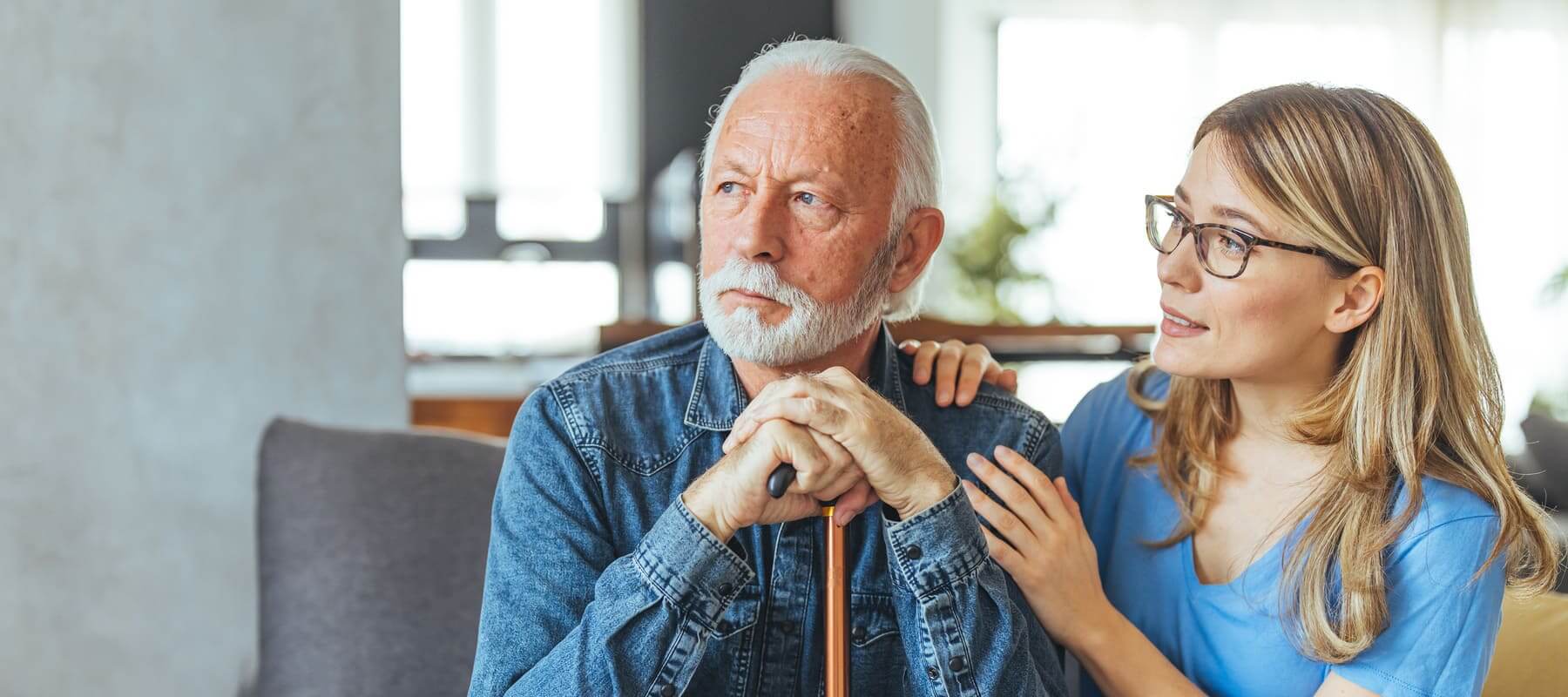Un señor mayor recibe el apoyo de una cuidadora. 
