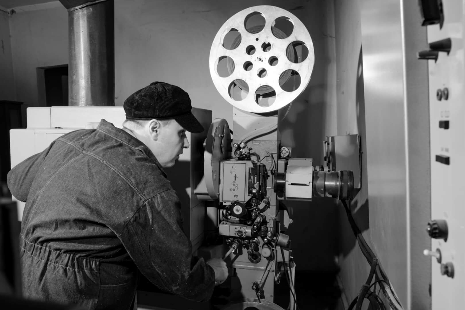 Un cámara grabando con una cámara de cine antigua en una imagen en blanco y negro. 