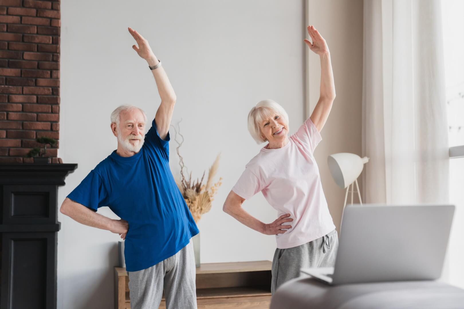 dos personas mayores haciendo gimnasia en casa